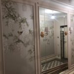 Пример 'элитного ремонта квартир': прихожая в стиле неоклассика, где художественная роспись на стенах сочетается с зеркальными панелями с фацетом.