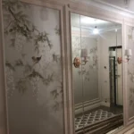 Пример 'элитного ремонта квартир': прихожая в стиле неоклассика, где художественная роспись на стенах сочетается с зеркальными панелями с фацетом.