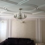 Пример 'элитного ремонта квартир': гостиная с кессонным потолком из гипсовой лепнины и стенами 'буазери' с декоративной штукатуркой.