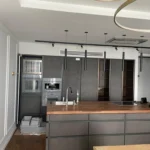 Функциональная 'кухня с островом': на деревянной столешнице установлена мойка и варочная панель.