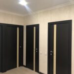 Результат 'отделки квартиры под ключ': установка комплекта современных межкомнатных дверей в коридоре с контрастной отделкой.