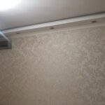 Финальный этап 'отделки квартиры под ключ': комната с классическими обоями с узором 'дамаск' и потолочной лепниной.