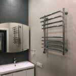 Результат 'отделки квартиры под ключ': ванная комната с контрастной отделкой, мебелью для ванной и современным электрическим полотенцесушителем.