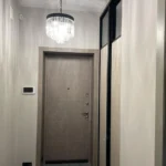 Пример 'элитного ремонта квартир': современный холл с дизайнерской хрустальной люстрой и отделкой стен.