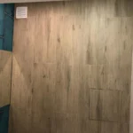 Пример грамотного 'монтажа инженерных коммуникаций': скрытый ревизионный люк, облицованный керамогранитом под дерево, в современном санузле.