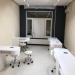 Результат 'отделки коммерческого помещения под ключ': полностью оборудованный маникюрный салон с рабочими местами и профессиональным трековым освещением.