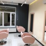 Завершенный 'ремонт салонов красоты в Москве': полностью оборудованные рабочие места парикмахера с дизайнерскими креслами и профессиональным освещением.